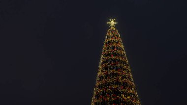 Noel ağacının ışıkları Bokeh 'i karanlık arka planda fotokopi aletiyle bulanıklaştırdı. Soyut şenlik arka planı. Metin için boşluk.