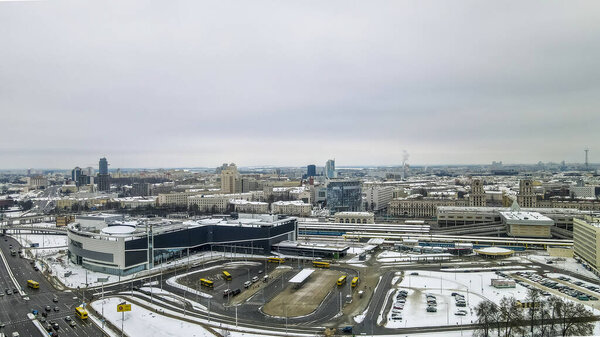 Aerial view of city transport hub railway and bus station. Aerial Central railroad station yard area in Minsk in winter. Commuting and travel concepts.