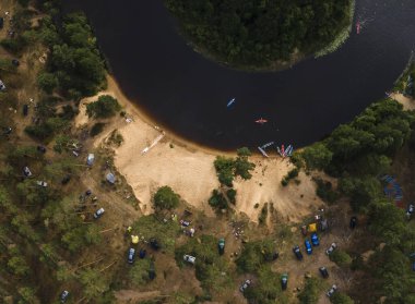 Nehir kıyısındaki kanolar. Turist kano iskelesi. Turist kampı, turist gezisi sırasında nehir eğlence teknesi iskelesi. Hava görünümü.
