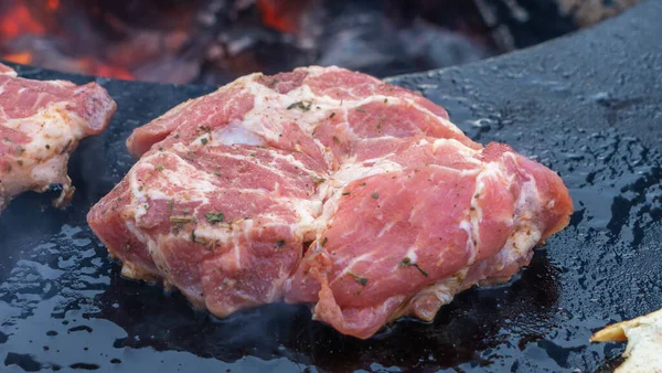 バーベキューの生ステーキ バーベキューグリルで牛ステーキのショットの真上 Bbqフードクローズアップ写真 ストリートフードのコンセプト 炭火焼のオーブンで豚や牛の肉の生地が焼けている — ストック写真