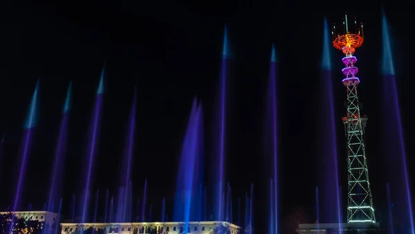 Телебашня Фестивальном Освещении Переднем Плане Фонтан Длительной Экспозицией Капли Воды — стоковое фото