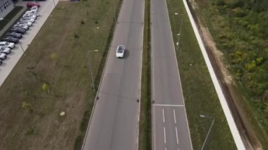 Test pistinde tur atan yeni bir elektrikli arabanın havadan görüntüsü. Geniş açıda elektrikli araba test sürüşü. Yeşil enerji kavramı.