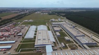 Gündüzleri endüstriyel kompleksin modern dış yüzeyi. Makineler için park yeri olan imalat yapısının hava görüntüsü.