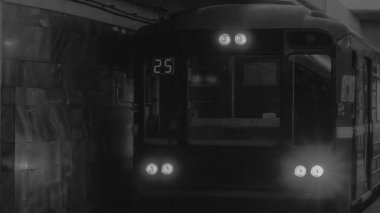 Siyah beyaz fotoğraf. Yeraltı treni hareket ediyor. Metro treninin istasyona varışı. Trafik sıkışıklığı olmayan şehir. Toplu taşıma kavramı.