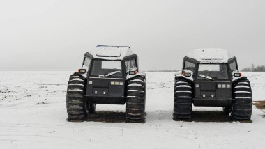Kış arka planında iki arazi aracı. Güçlü off-road ışınlayıcısı. Motor, çapraz.