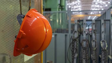 Tehlikede olan işyerinde çalışan fabrika işçisi için turuncu başlık emniyeti ve mesaj için yer. Güvenlik işi konsepti. Sektör arkaplanı.
