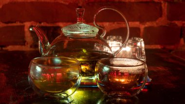 Kaynar su ve söğüt ağacı ya da çaydanlıkta çay. İki bardak çay fincanı. Kırmızı tuğla arkaplan.