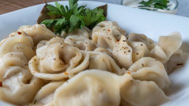 Kaynamış etli börek. Rus kaynamış pelmeni 'nin beyaz tabakta yakın plan görüntüsü. Haşlanmış ev yapımı Rus köftesi ya da etli pelmeni..