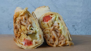 Shawarma tavuk sarması. Izgara et, peynir, lahana, havuç, sos ve yeşille doldurulmuş taze lavaş veya pita ekmeği. Geleneksel Doğu atıştırması.