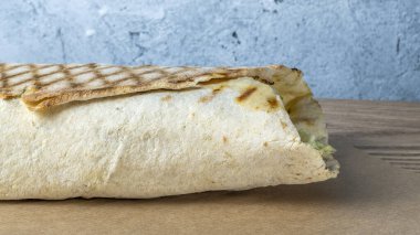 Shawarma tavuk sarması. Izgara et, peynir, lahana, havuç, sos ve yeşille doldurulmuş taze lavaş veya pita ekmeği. Geleneksel Doğu atıştırması.