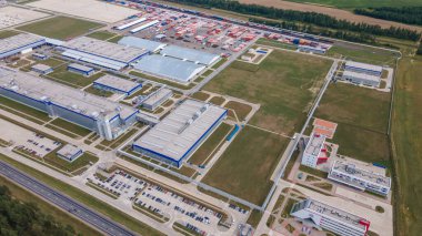 Gündüzleri endüstriyel kompleksin modern dış yüzeyi. Makineler için park yeri olan imalat yapısının hava görüntüsü.
