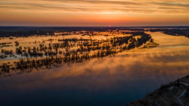 Gün batımında suların yükseldiği bir dönemde ağaçları sel basmış. Alacakaranlıkta sular altında kalan ağaçlar, Belarus 'un Turov kenti yakınlarındaki Pripyat Nehri' ni sel basıyor. Doğa ve seyahat kavramı.