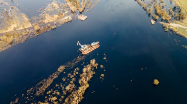 Nehirde kumu tazeleyen tarağın havadan görünüşü. Kanal kazıcı tarafından taranıyor. Tekne vincinin en üst görüntüsü. Endüstriyel kavram.