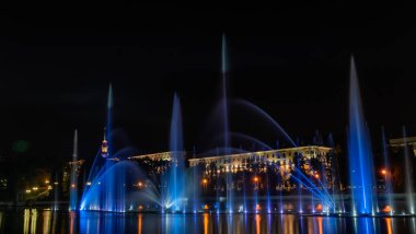 Geceleyin bir nehirde çok renkli bir müzik çeşmesi. Aydınlanmadan kaynaklanan gece çeşmesi. Mesaj için yer var. Kutlama konsepti.