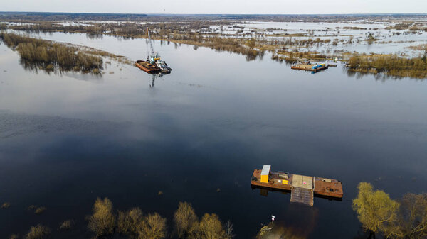 Древний ручной переход через реку. Автомобиль перевозится через реку на речном пароме. Вид сверху на природу Беларуса. Река Припять в Беларуси.