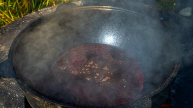 Büyük bir kazanda şarap kaynattım. Sıcak şarap büyük bir tencerede pişirilir. Geleneksel festivalde vitaminler. Çeşitli meyve ve baharatlarla sıcak şarap.