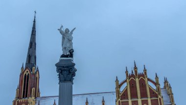 Geleneksel bir Başmelek Michael heykeli dramatik gökyüzüne ve kilise kulesine karşı şeytana mızrakla vuruyor. Mesaj için yer var. Din kavramları.