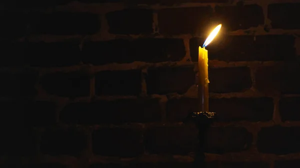 Karanlık bir arka planda mum alevi yakın plan. Eritilmiş mum ışığı sınır tasarımı. Uzun pozlama. Karanlık. Gece yanıyor, mum ışığı. Geniş Ekran