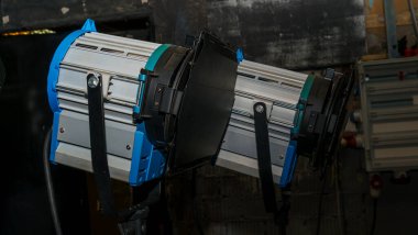 Karanlık arka planda bir film ve televizyon programı için güzel stüdyo ışıkları. Sinema üretimi için profesyonel ışık. Nesne arkaplanı.