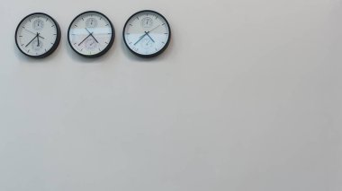 Dünyanın farklı başkentlerinde zamanı gösteren üç duvar saati. Metin için boşluk.