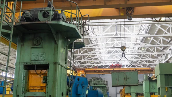 Ulaşım, üretim ve üretim için vinç veya köprü vinç kaldırma işlemini içerir. Vinç üzerindeki fabrika deposu yükü kaldırıyor.,