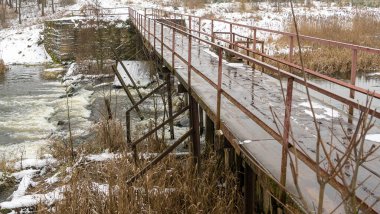 Küçük bir nehrin üzerinde eski bir köprü. Kırsal bölgedeki ilk kar. Metin için boşluk.