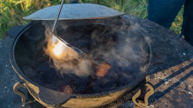 Büyük bir kazanda şarap kaynattım. Sıcak şarap büyük bir tencerede pişirilir. Geleneksel festivalde vitaminler. Çeşitli meyve ve baharatlarla sıcak şarap.