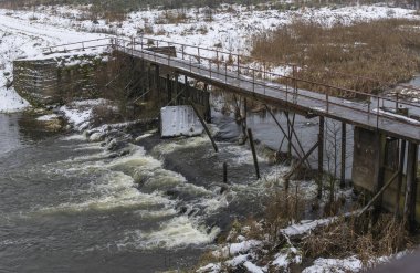 Küçük bir nehrin üzerinde eski bir köprü. Kırsal bölgedeki ilk kar. Metin için boşluk.