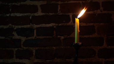 Karanlık bir arka planda mum alevi yakın plan. Eritilmiş mum ışığı sınır tasarımı. Uzun pozlama. Karanlık. Gece yanıyor, mum ışığı. Geniş Ekran