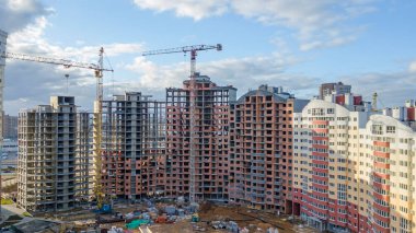 Klasik mavi gökyüzüne karşı inşaat halindeki vinçler ve binalar inşa ediyorlar. İnşaat konsepti.