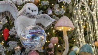 Kuş şeklinde bir Noel oyuncağı. Süslü Noel ağacı geçmişi. Mutlu yıllar konsepti. Işıklı bulanık arkaplan.