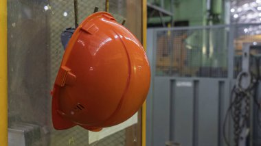 Tehlikede olan işyerinde çalışan fabrika işçisi için turuncu başlık emniyeti ve mesaj için yer. Güvenlik iş konsepti.