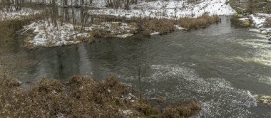 Kış manzarasında küçük bir nehir. Küçük Nehir, ağaçlar ve ilk karlı kış manzarası. Doğa kavramları. Metin için boşluk.