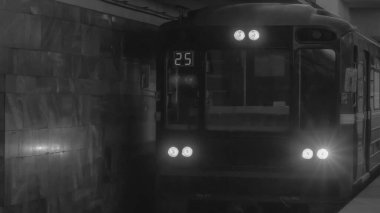 Siyah beyaz fotoğraf. Yeraltı treni hareket ediyor. Metro treninin istasyona varışı. Trafik sıkışıklığı olmayan şehir. Toplu taşıma kavramı.