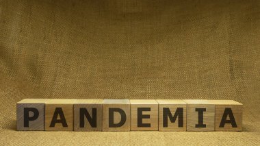 Tahta küplerin arka planında siyah kelime PANDEMIA var. Pandemia ve Covid-19 konsepti.