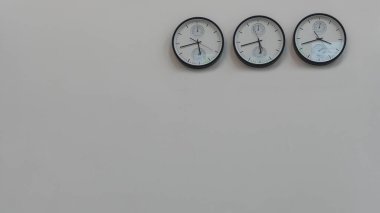 Dünyanın farklı başkentlerinde zamanı gösteren üç duvar saati. Metin için boşluk.