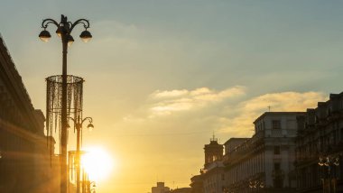 Şehrin tarihi merkezinde gün batımında binaların siluetlerini ve sokak ışıklarının panoramik görüntüsü. Kentsel kavramlar.