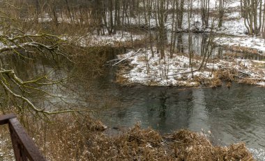 Kış manzarasında küçük bir nehir. Küçük Nehir, ağaçlar ve ilk karlı kış manzarası. Doğa kavramları. Metin için boşluk.