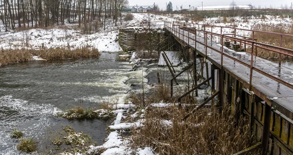 小さな川の上に古い歩道橋 田舎で最初の雪 テキストのスペース — ストック写真