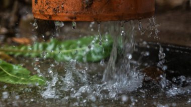 Şiddetli yağmur. Yağmur suyu çatıdan drenaj borusuna akıyor..