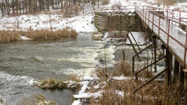 Küçük bir nehrin üzerinde eski bir köprü. Kırsal bölgedeki ilk kar. Metin için boşluk.