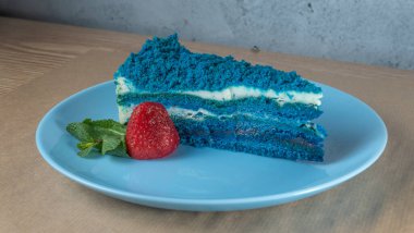 Çilekli mavi pasta ve açık mavi tabakta nane yaprağı. Üst Manzara. Bayram tatlısı konsepti doğum günü için. Metin için boşluk.