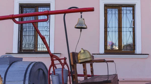 古色古香的皮革消防员头盔和墙上的旧信号铃 消防概念 物体背景 — 图库照片