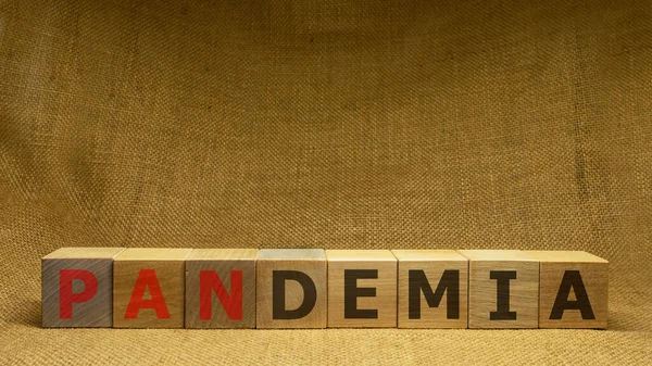 Tahta küplerin arka planında kırmızı ve siyah kelime PANDEMIA var. Pandemia ve Covid-19 konsepti. Nesne arkaplanı.