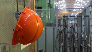 Tehlikede olan işyerinde çalışan fabrika işçisi için turuncu başlık emniyeti ve mesaj için yer. Güvenlik iş konsepti.