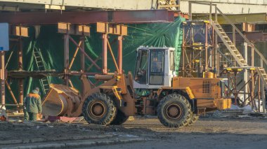 Otoyol inşaatında. Köprü inşaat alanında turuncu buldozer. Dolambaçlı. Yol Kapalı. Otoyol. Şehirdeki otoyol ve köprü onarımı ve inşaatı.