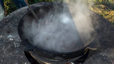 Büyük bir kazanda şarap kaynattım. Sıcak şarap büyük bir tencerede pişirilir. Geleneksel festivalde vitaminler. Çeşitli meyve ve baharatlarla sıcak şarap.
