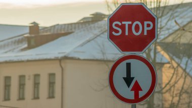 Yol işaretleri. Gelen trafiğin avantajı ve binanın arka planında Stop Road. Seçici odaklanma ve bokhe. Sokak işaretleri.