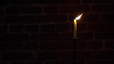 Karanlık bir arka planda mum alevi yakın plan. Eritilmiş mum ışığı sınır tasarımı. Karanlık. 4k çözünürlüklü video. Gece yanıyor, mum ışığı. Geniş Ekran.