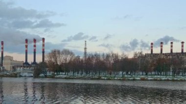 Şehrin ortasındaki fabrika suyun yanında hava kirliliğine neden oluyor. Kışın termik santraller. Ekoloji kirliliği. Fabrika boruları kalın beyaz duman buharı.